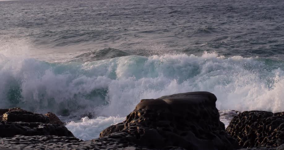 Close up of waves crashing on rocks on the coast