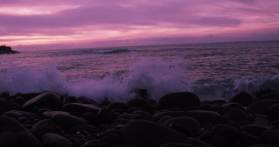 Waves crashing on rocks at sunrise on the coast