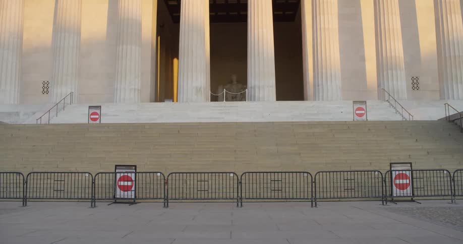 A statue is blocked off with a fence and signs