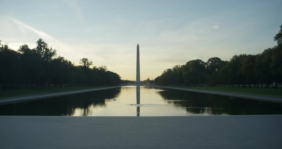 A bird dips in to a river in front of a large tower monument