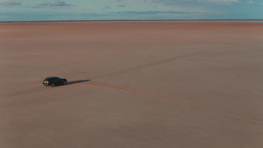 A vehicle drives across a desert terrain