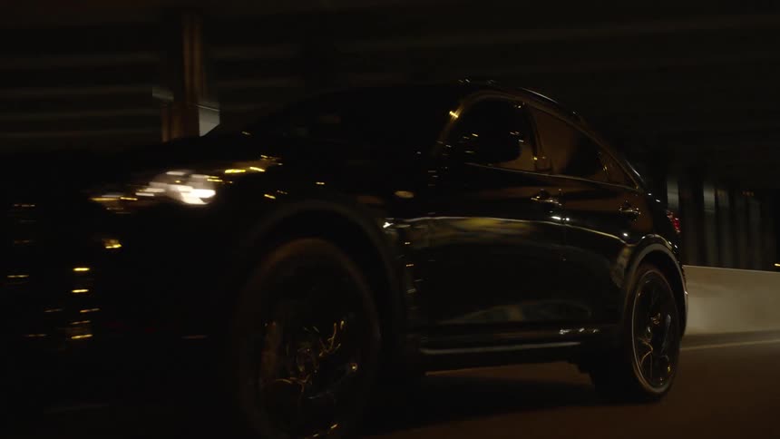 A car traveling beneath a bridge on a freeway at night