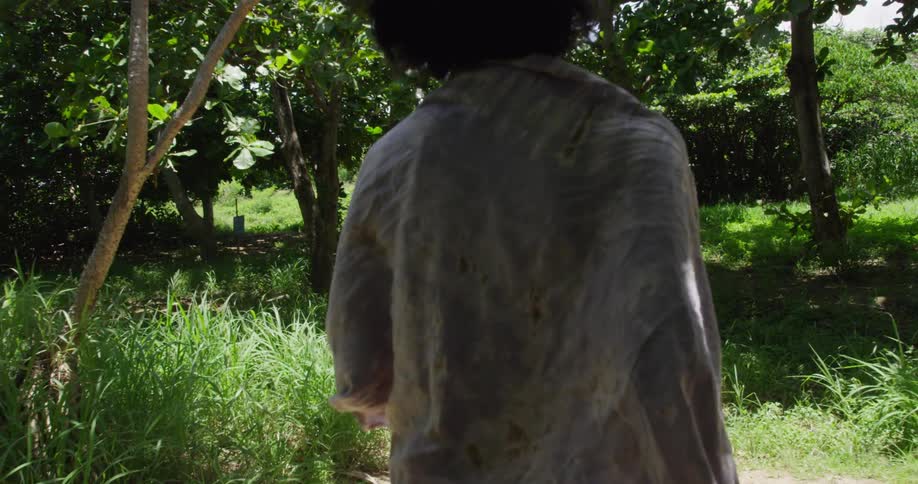 Woman with towel in her shoulders walks on a dirt path outdoors