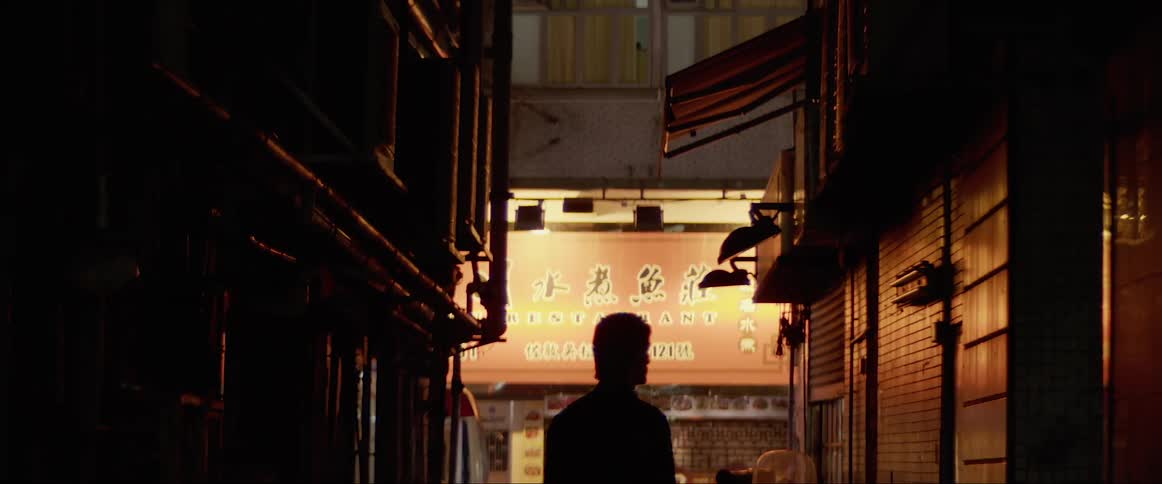 A man stands in the middle of an asian neighborhood in a city