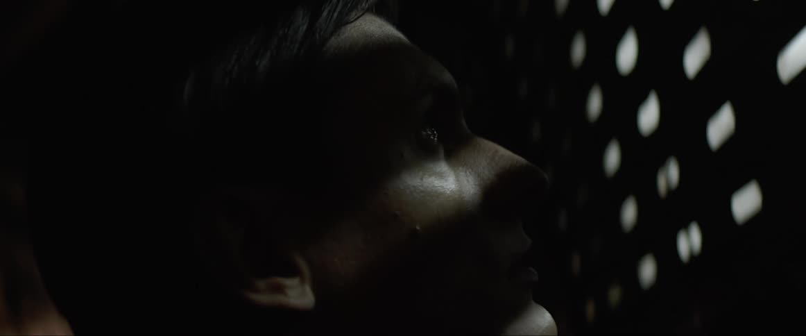 Close up of a man standing in a dimly lit corridor
