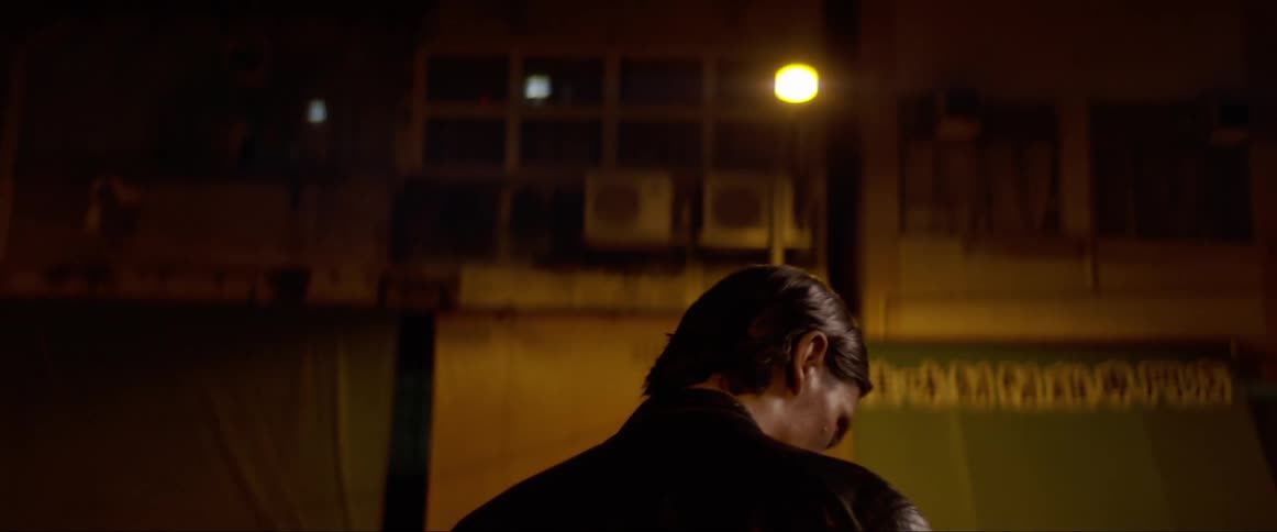 Man wearing leather jacket stand on a street at night