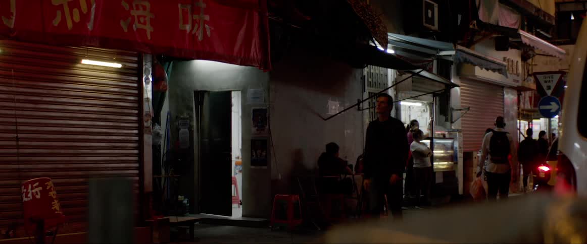 A man walking through the crowded streets of an asian city at night