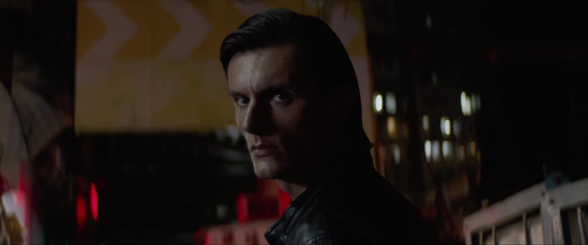 A man is standing in a dark alley