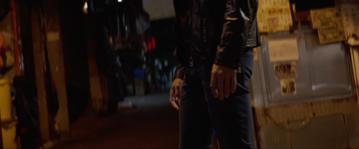 Man stands and turns around in the alley at night