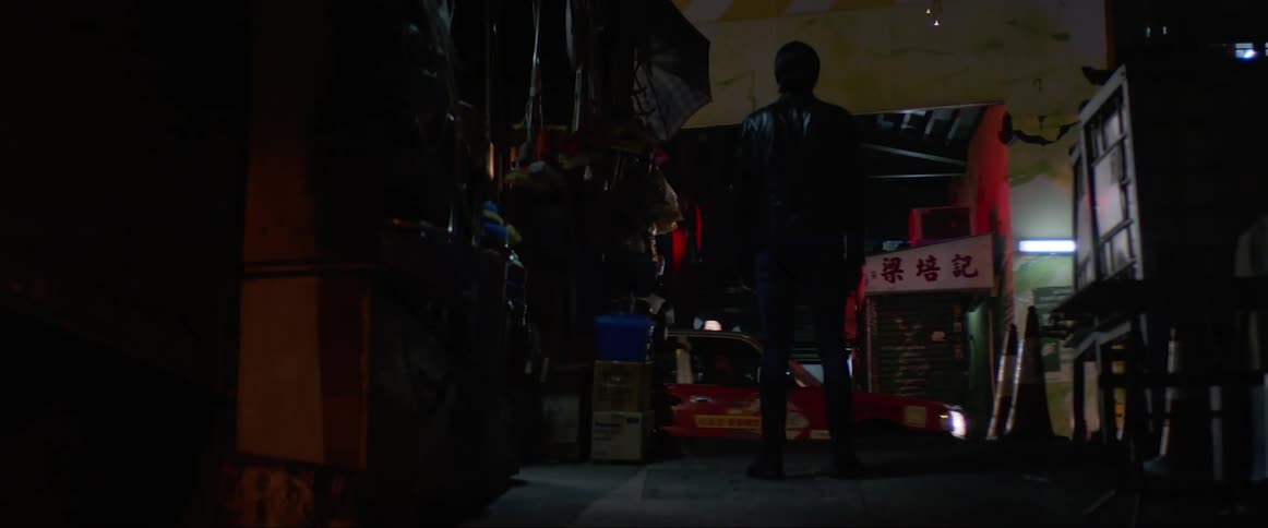 Man wearing leather jacket stands still on the street at night