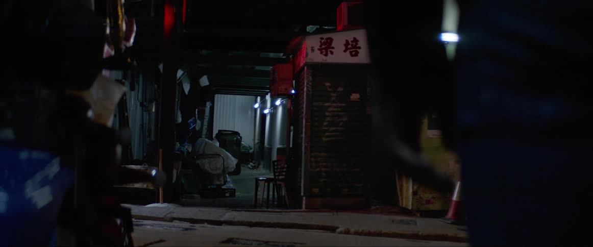A man stands and looks at a dark and empty street