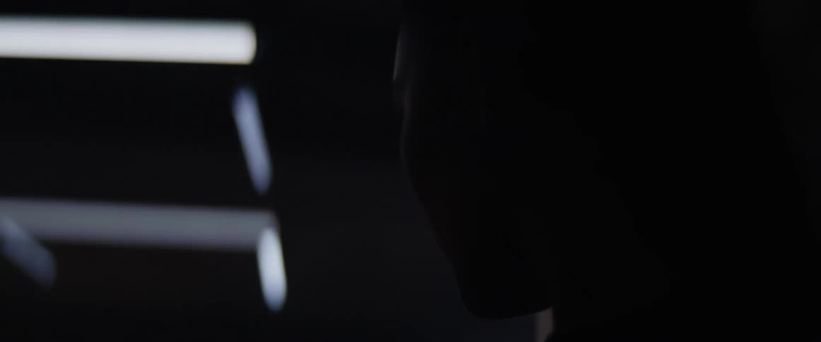 An asian woman stands in a room with lights that throb