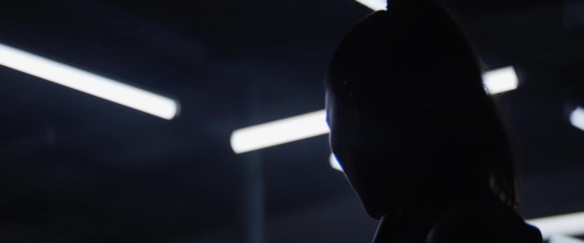 A person is looking towards flashing lights in back of her