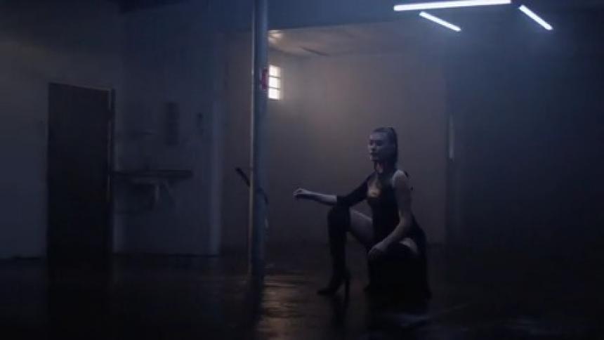 An asian woman sits alone in a darkened room
