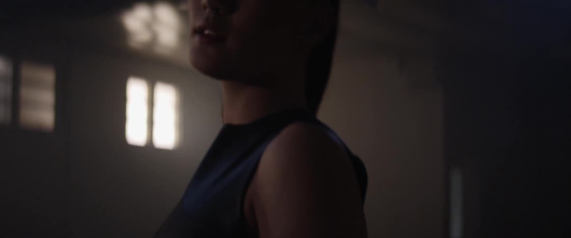 An asian woman inside a building walks and looks around
