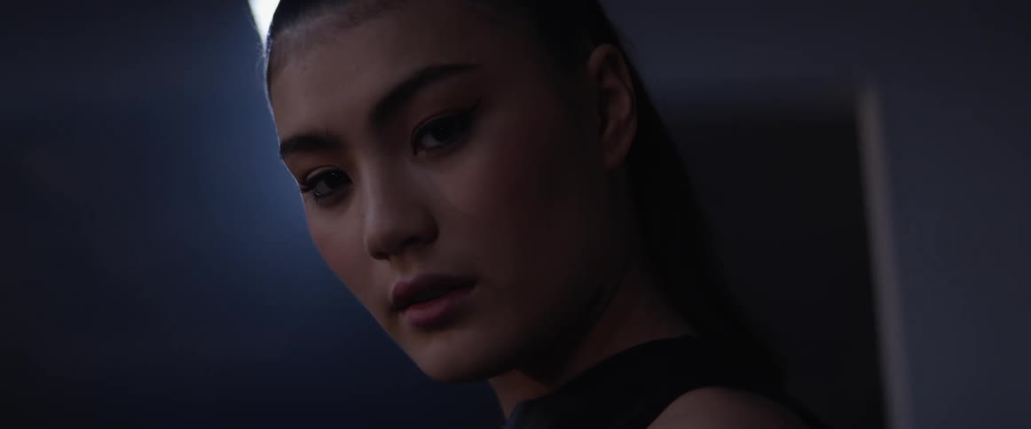 An asian woman looks around a room