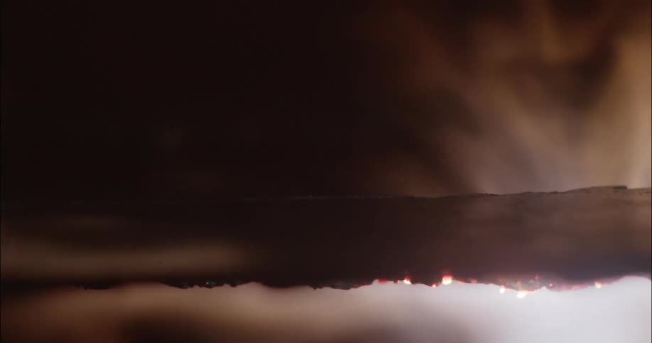Flames rise up from under a metal grate