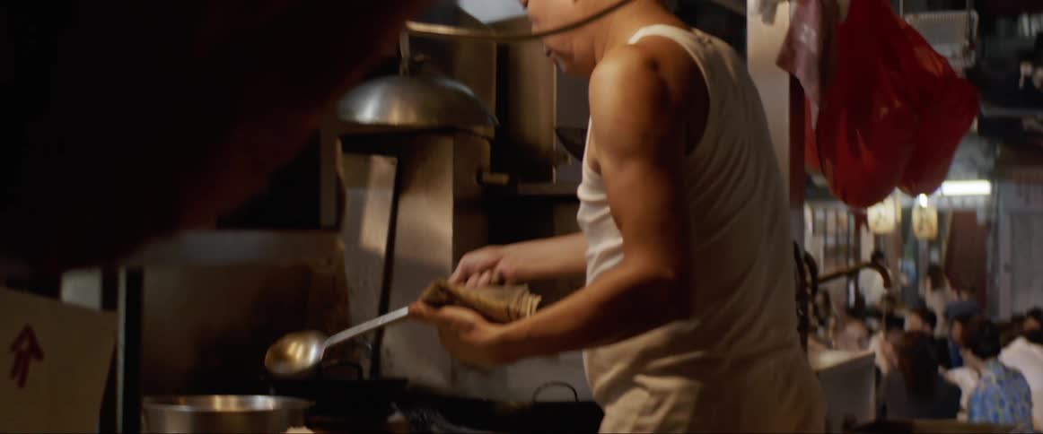 A male cook works in a restaurant kitchen at the stove