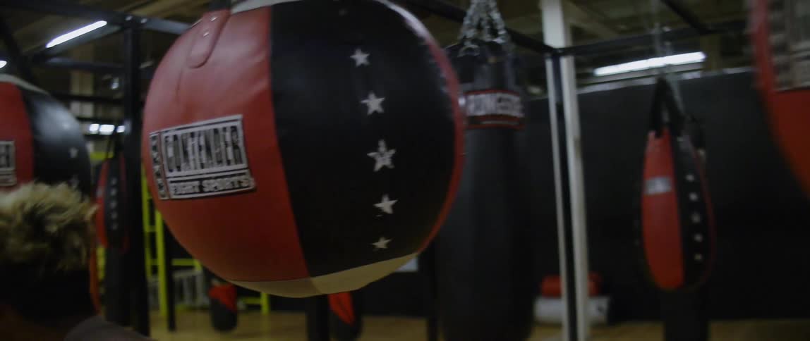 A young man weaves his way through punching bags