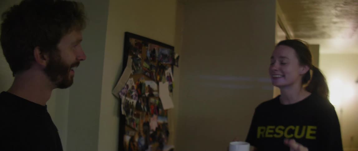 Man and woman holding cups stand and talk to each other at home