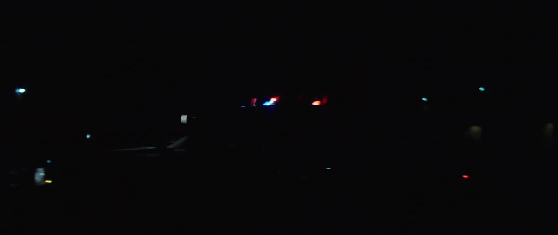 Police car with flashing lights travels on the road in the night