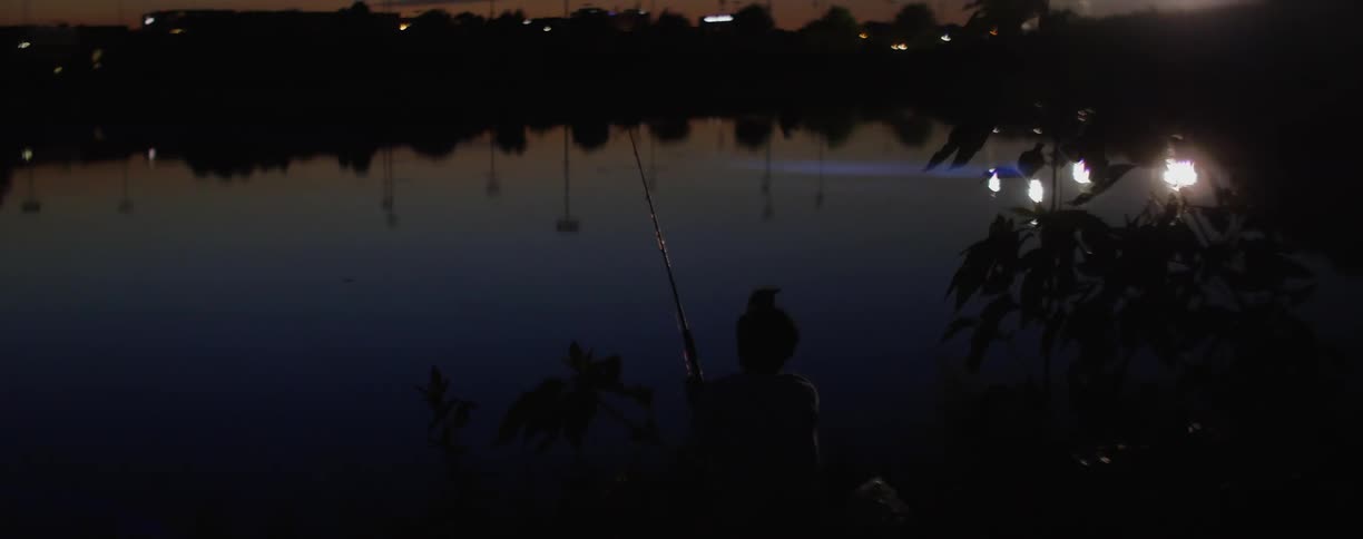 Sparks and lights reflected in the still surface of a body of water