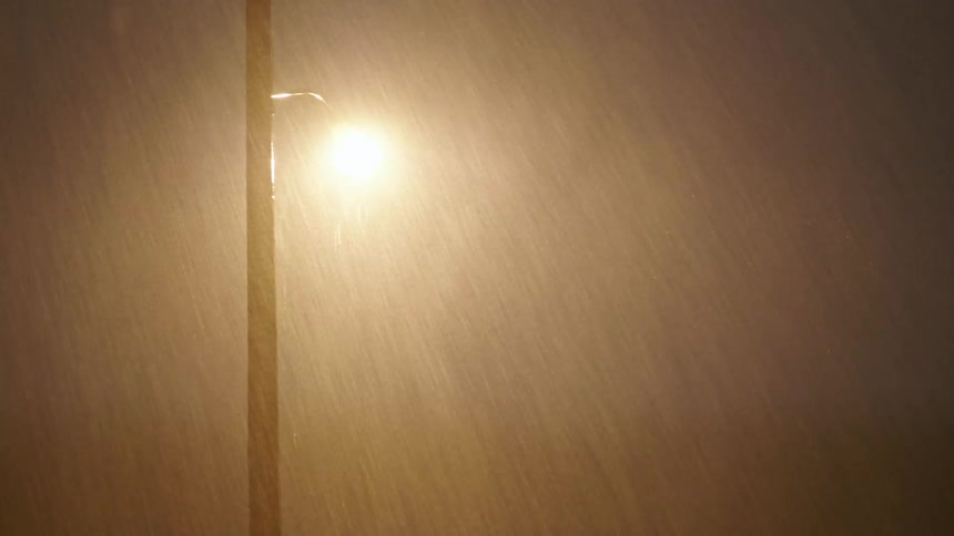 Heavy rain and lightning falling on a street light at night