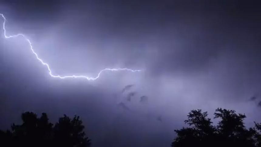 Lightning arcs across a night sky