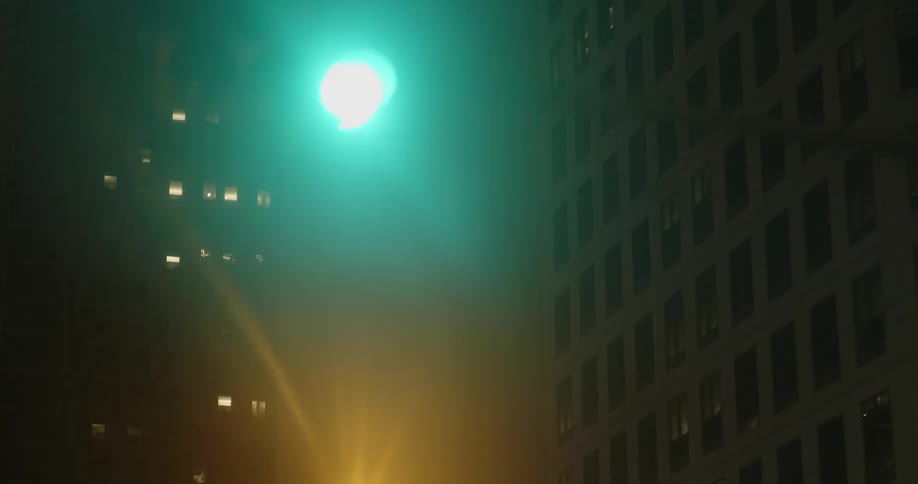 Vehicle drives on highway passing office buildings at night in the city