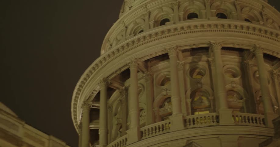 A historical building has a domed top with a balcony going all the way around