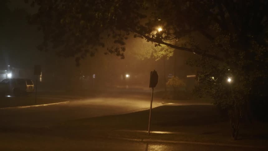 A neighborhood gets socked with a rain storm at night