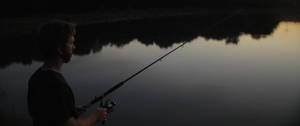 A man is fishing at sunset