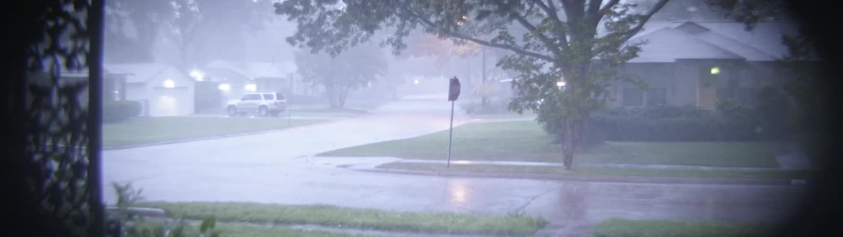 A rain storm moves through a neighborhood at night