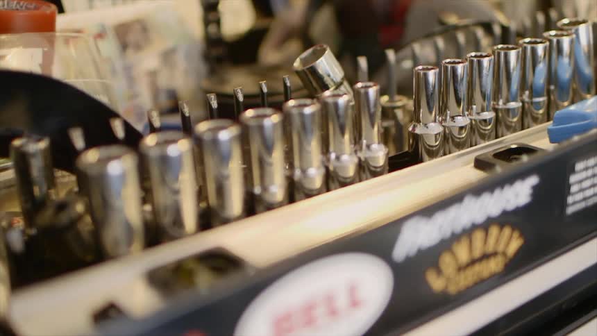 Sockets and other tools occupy workbench near license plate and pictures
