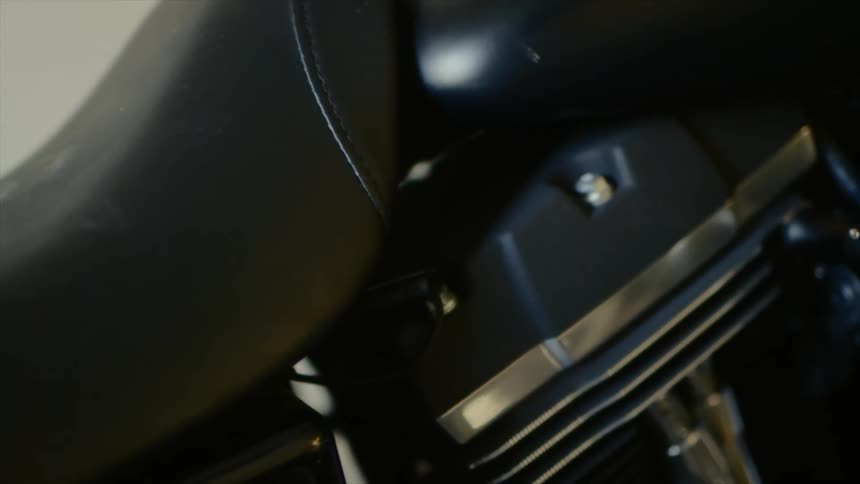 A black motorcycle sits on a display in a room