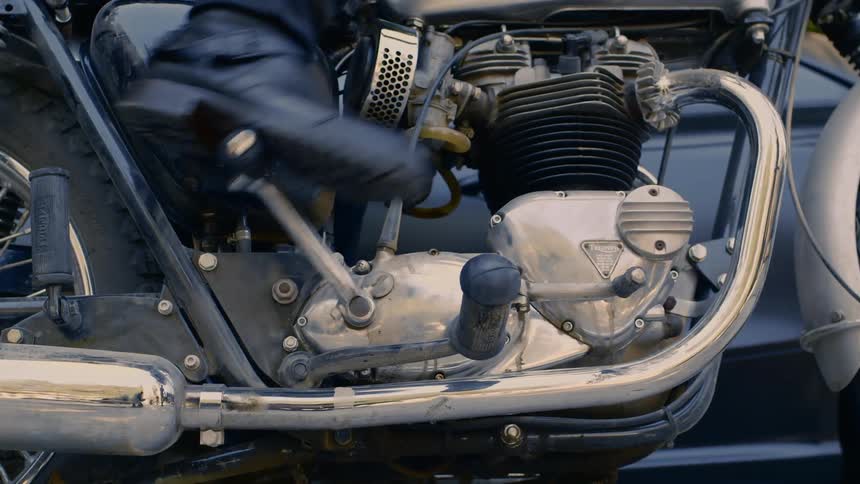 A man pressing down on the clutch on his motorcycle with his foot