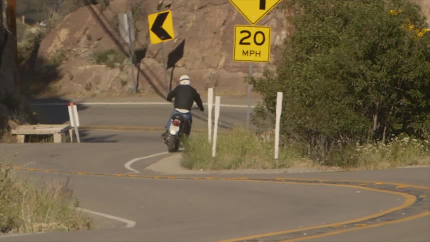 A motorcycle rider drives his bike down a twisting road