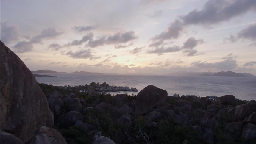 Piles of large rocks sit on an ocean coastline
