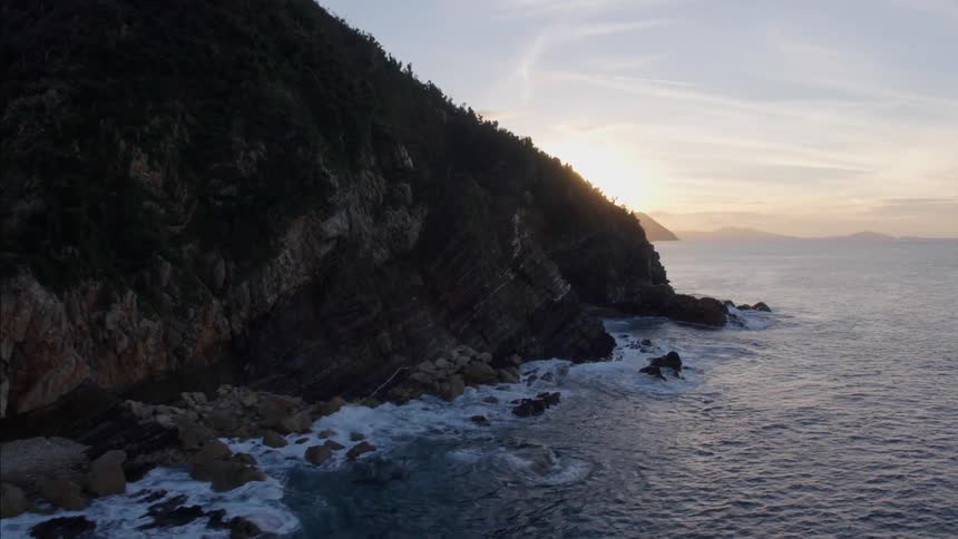 Aerial view of sunset over the ocean between mountains