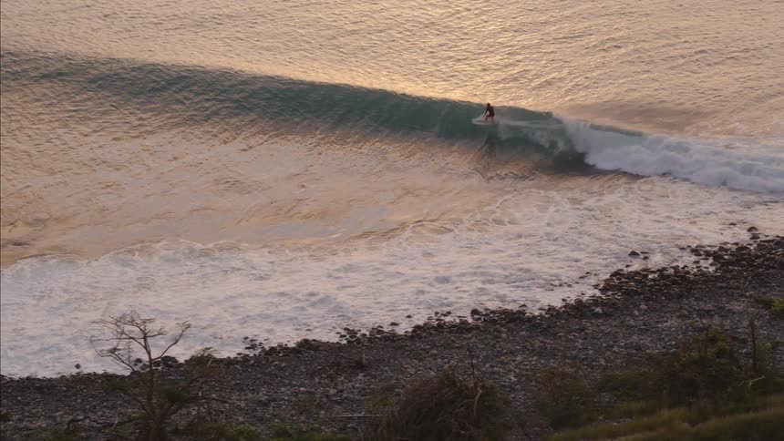 A person is surfing a wave near the shore
