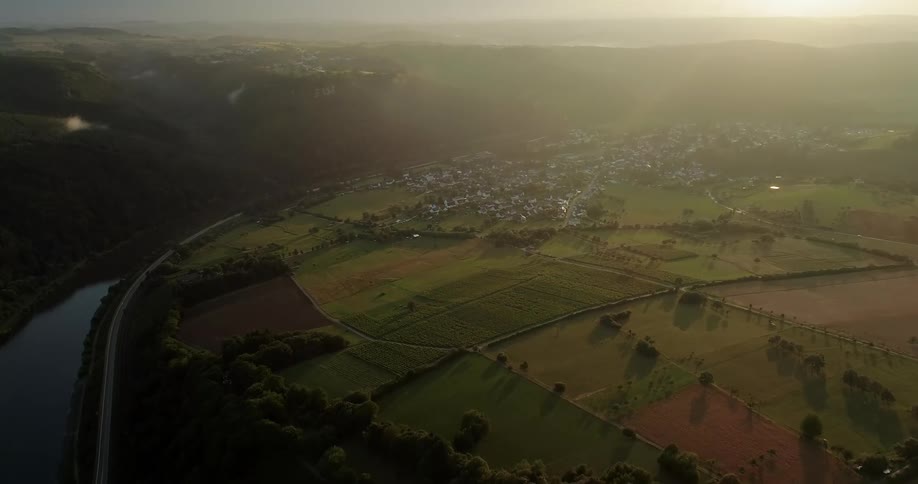 A small rural town sits near farmland and a river