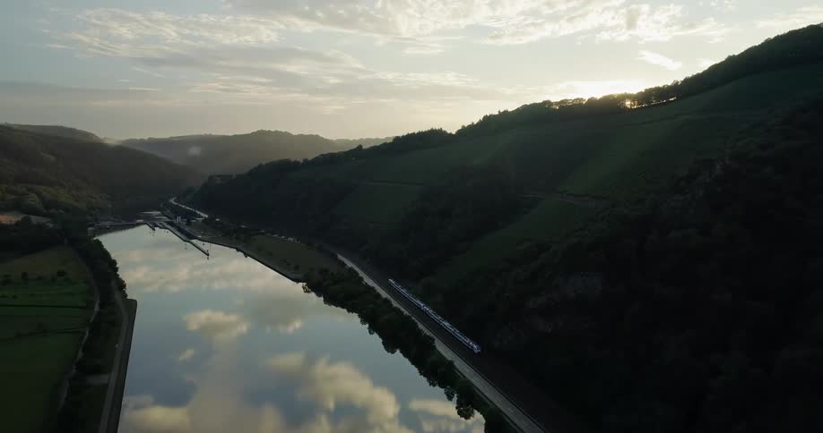 A train is traveling alongside the hill