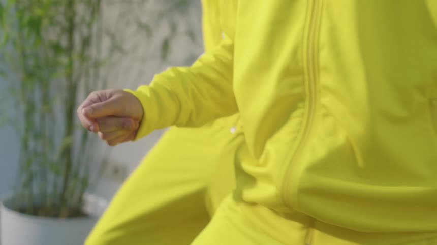 Three people dance while wearing yellow suits