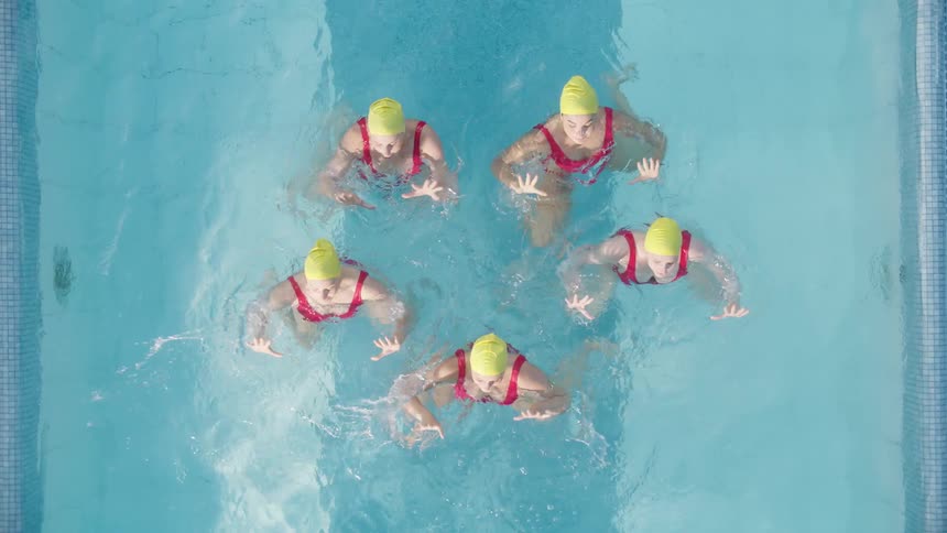 Five women do a dance in the pool