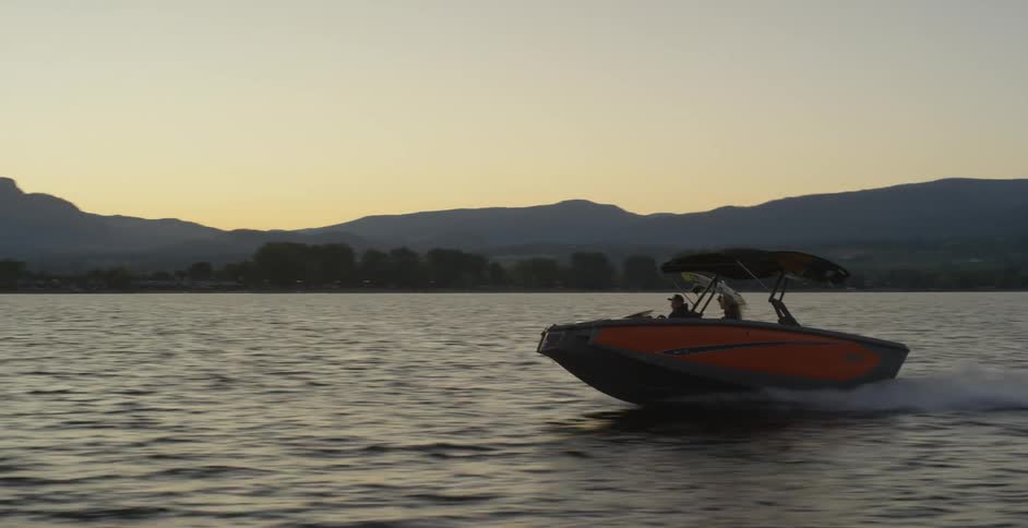 A man and woman driving in a boat across a lake