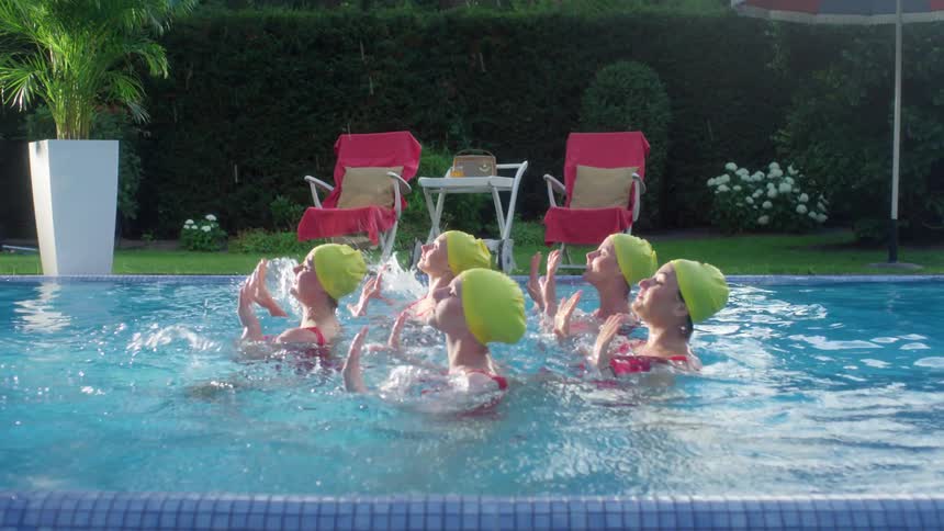 A group of women synchronize a routine in the pool together