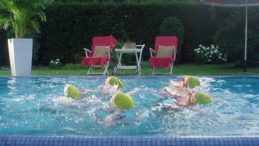 Five women synchronize swim in an outdoor swimming pool