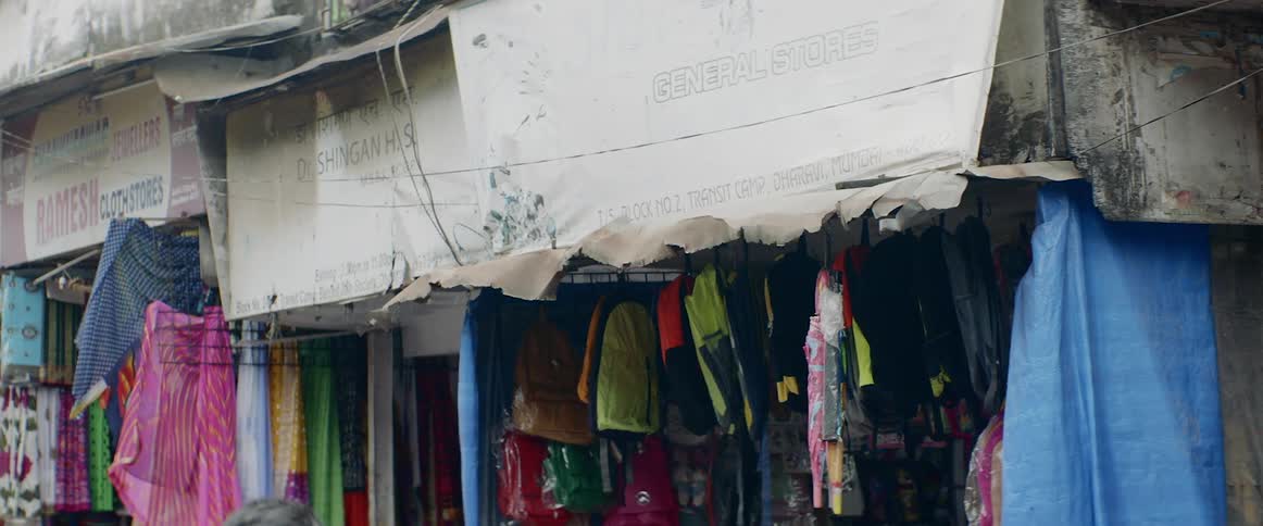 People walking by clothes store in a village