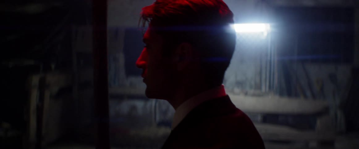 A man walking past a dimly lit room