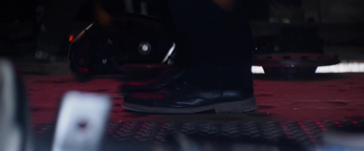 A person is walking through a shop as sparks fly